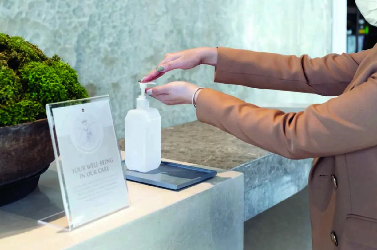 Customer using hand sanitizer at business